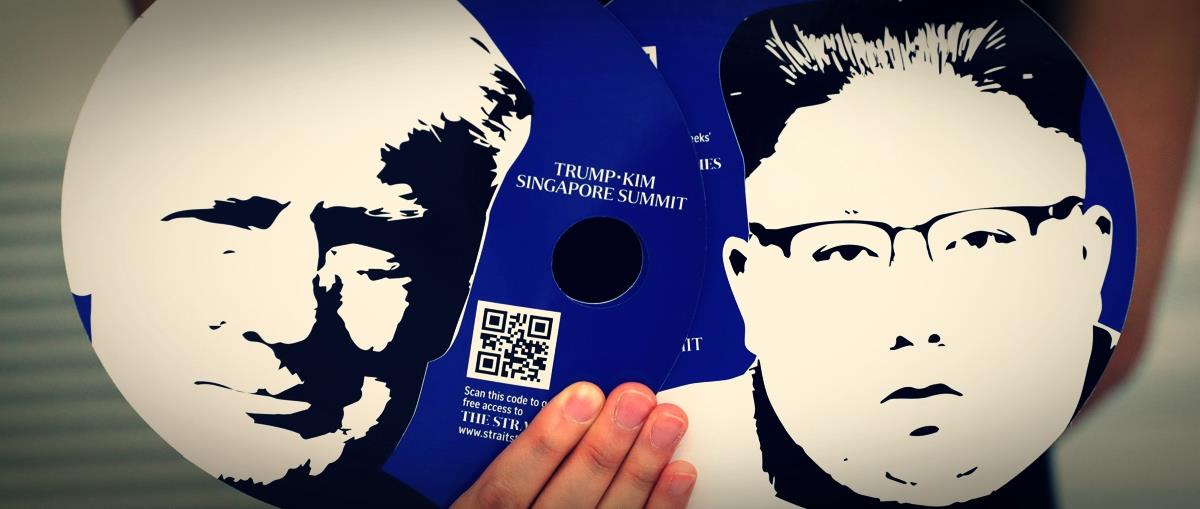 A worker of a media center for the summit between the U.S and North Korea shows fans featuring the images of U.S. President Donald Trump and North Korean leader Kim Jong Un, which provided for journalists in a media kit at the media center in Singapore
